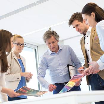 Toner-only innovation colleagues discussing coloured printouts